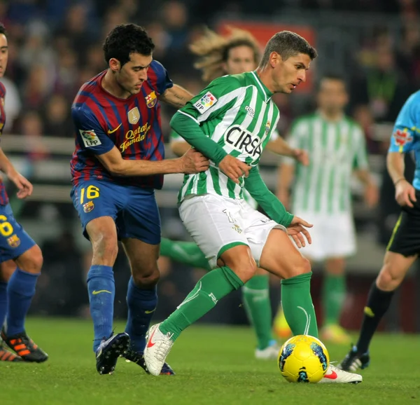 Salva Sevilla (R) del Real Betis compite con Sergio Busquets (L) del FC Barcelona —  Fotos de Stock