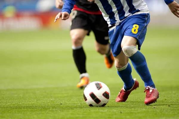 Jogador de futebol pernas em ação — Fotografia de Stock