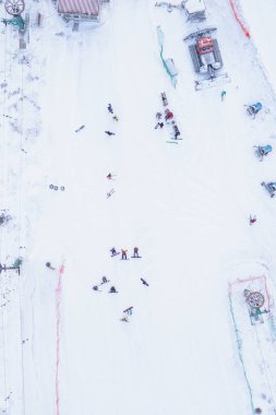 Kış mevsiminde kar yamacında kayakçılar ve snowboardcular.
