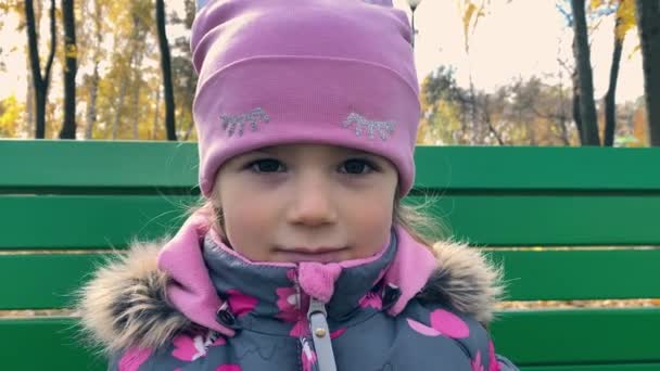 一个4岁的小女孩戴着粉红的帽子，穿着夹克衫，微笑着特写 — 图库视频影像