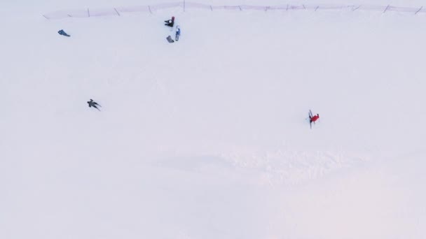 El esquiador principiante con chaqueta roja entrena y aprende a frenar y esquiar giros: tiro con dron. — Vídeo de stock