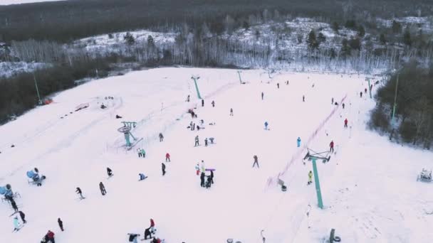 Skifahrer und Snowboarder auf Schneehängen mit Skilift. — Stockvideo