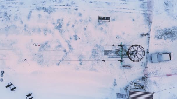 スキーリフトの車輪が回転します。雪の山の斜面にスキーリフト。垂直ビデオ. — ストック動画