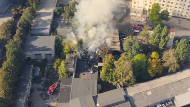 The fire brigade works to put out a fire in the city: drone aerial shot. — Vídeo de Stock