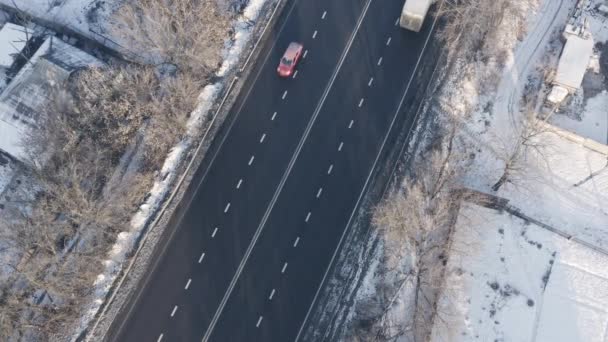 Witte vrachtwagen met oplegger rijdt langs zwarte asfaltweg: bovenaanzicht statische drone schot. — Stockvideo