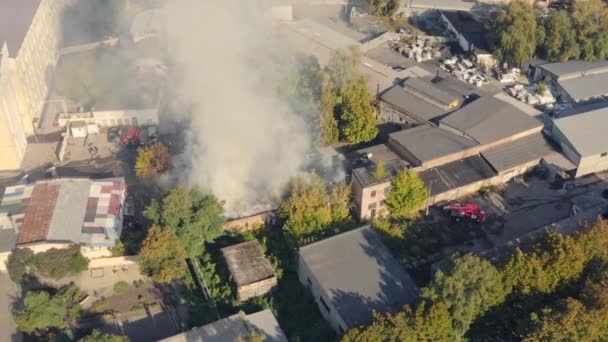 Equipe de resgate com caminhão de bombeiros e bombeiros trabalha para apagar um incêndio na cidade: tiro órbita drone — Vídeo de Stock