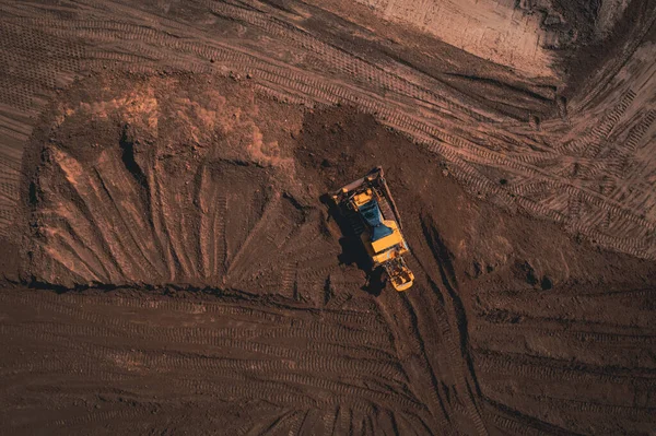 Yellow tracked bulldozer performs earthworks - aerial view shot ロイヤリティフリーのストック写真