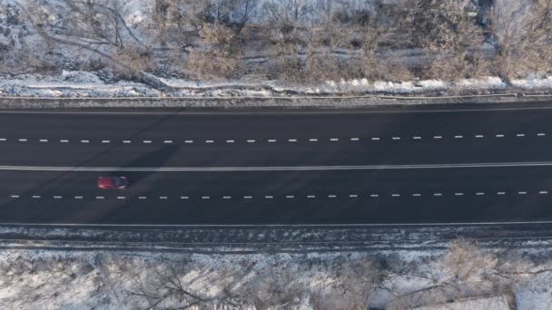 Auta v silničním provozu podél černé asfaltové dálnice: horní pohled drone shot. — Stock video