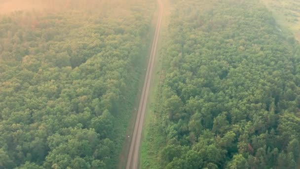 Drone flight over an empty railway at dawn - aerial view of railway at summer morning. — Video