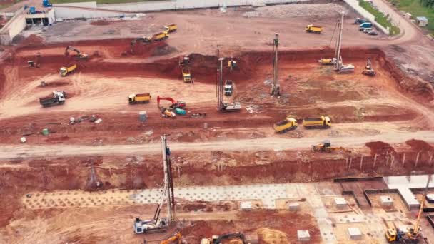 Obras de equipo de construcción en el sitio de construcción: excavadoras, camiones y excavadoras - plano aéreo — Vídeos de Stock