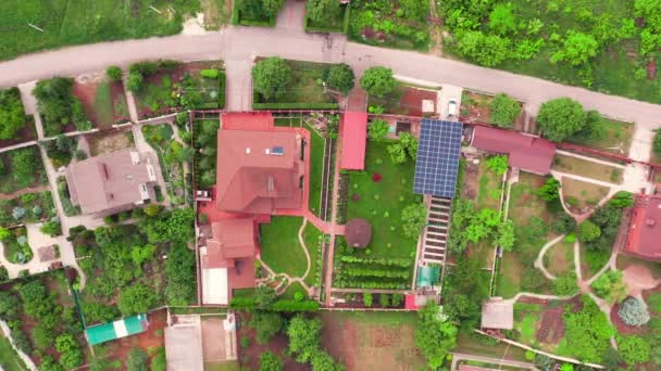 Μοντέρνο εξοχικό σπίτι ανάμεσα σε πράσινο γρασίδι και κήπους: ιδιωτικό σπίτι - top view drone shot. — Αρχείο Βίντεο