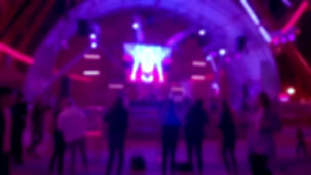 Dansar på disco med neonstrålar av ljus och hologram. Begreppet ungdomars nattliv. — Stockvideo