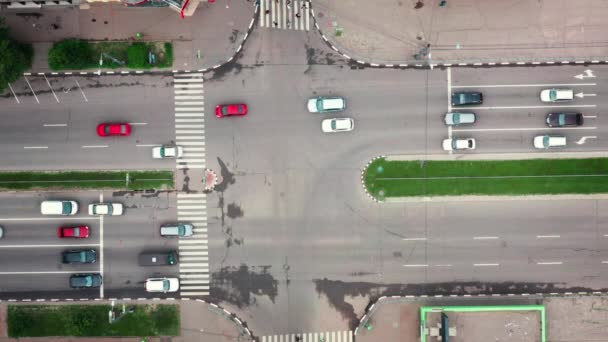 Os carros passam pelo cruzamento da estrada multi-pista da cidade. Tráfego rodoviário no cruzamento da cidade - vista superior. — Vídeo de Stock