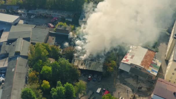 Záchranný tým s hasičským vozem a hasiči pracuje na hašení požáru ve městě: drone shot. — Stock video