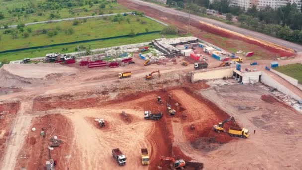 Trabajos de excavación de la construcción en el sitio de construcción: camiones y plataformas de perforación - tiro de inclinación de drones — Vídeos de Stock