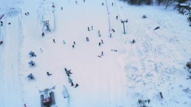 Kayakçılar ve snowboardcular kar yamaçlarında kayak yapıyorlar..