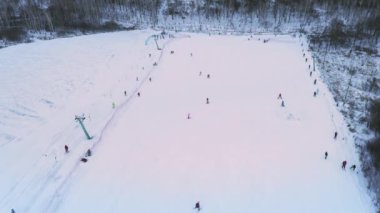 Karlı bir kış günü, Kayakçılar ve Snowboardcularla kayak merkezinin insansız hava aracı görüntüsü..