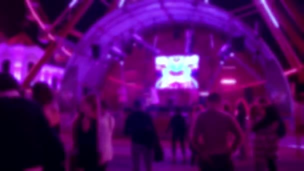 Táncoló emberek a disco koncerten neonsugarakkal. Homályos kép a fiatalokról Éjszakai élet. — Stock videók
