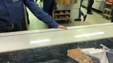 McDonalds çalışanları tezgahın yanında mavi elbiseli yeni tasarım işiyle uğraşıyorlar.