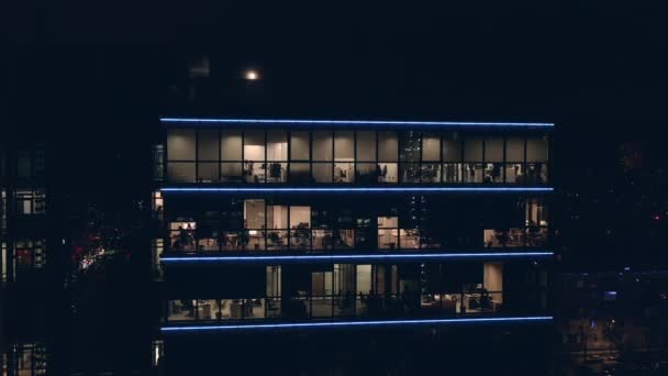 Lidé pracují v kancelářích ve velkém moderním business centru s průhlednými panoramatickými okny.