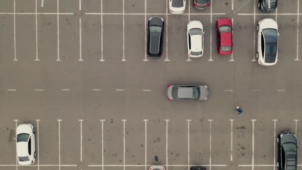 Kocsi bérlet dobja a parkolót. Autó elhagyja a parkolót - légi felső drón lövés. — Stock videók
