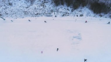 Karlı bir kış gününde Kayakçılar ve Snowboardcularla karlı yamaçlarda uçan insansız hava aracı.