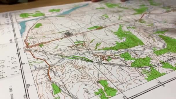 Een militaire officier geeft topografische tekens aan op een kaart van het gebied. — Stockvideo