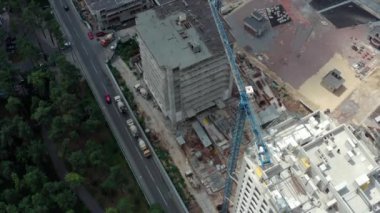 Parka yakın kentte yeni daireler inşa ediliyor. Şehrin yeniden inşası ve restorasyonu. Çok katlı evlerin inşaatı: vinçli ve inşaatçılı inşaat alanı: İHA atışı.