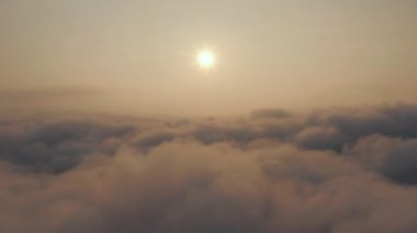 Bulutların üzerindeki Güneş 'e Atmosferik Uçuş: Bulutların arasında yüksek irtifada İHA uçuşu. Dolly İHA çekiminde. Sisin üzerinde yüksek irtifada gün batımı. Güneşe ve gökyüzüne karşı bulut hareketi