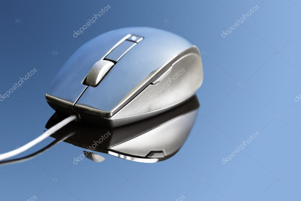 Stylish shot of a non descript Computer Mouse. There are no logos or copyrights present. Shot on a reflective surface with a blue gel. Contrast has been added to give the mouse a glossy lustre look. No sharpening added