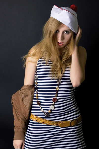 Attractive young lady in sailor dress and hat in studio on the b — Stock Photo, Image