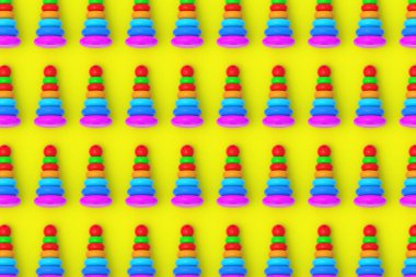 Sarı arka planda oyuncak piramitleri. Çocuk eğitimi. Eğitici oyunlar. Okul öncesi gelişim. Üst Manzara. 3d hazırlayıcı