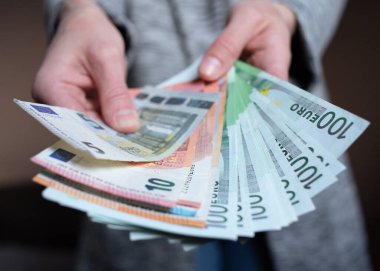 Kadın para sayıyor. Kadınların elinde nakit para banknotları var. 5, 10, 100 euro para birimi. İş adamı zengin kadın elleri nakit para banknotları ya da kağıt banknotlar tutar ve sayar