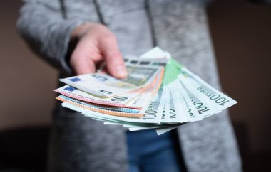 Kadın para sayıyor. Kadınların elinde nakit para banknotları var. 5, 10, 100 euro para birimi. İş adamı zengin kadın elleri nakit para banknotları ya da kağıt banknotlar tutar ve sayar