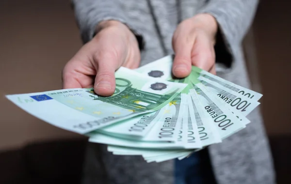 Kadın para sayıyor. Kadın elinde 100 Euro 'luk nakit para banknotları var. İş adamı zengin kadın elleri nakit para banknotları ya da kağıt banknotlar tutar ve sayar