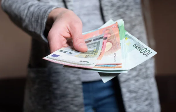 Kadın para sayıyor. Kadınların elinde nakit para banknotları var. 5, 10, 100 euro para birimi. İş adamı zengin kadın elleri nakit para banknotları ya da kağıt banknotlar tutar ve sayar