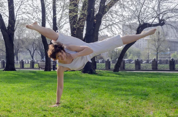 Young girl doing split on training outdoor — Stock Photo, Image