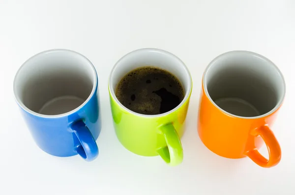 Trzy kubki prosto z kubek kawy w centrum. — Zdjęcie stockowe