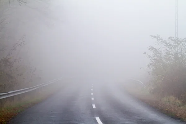 Estrada de asfalto em uma névoa de outono — Fotografia de Stock