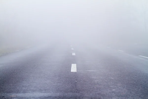 Estrada de asfalto em uma névoa de outono — Fotografia de Stock