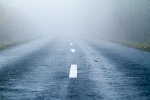 Estrada de asfalto em uma névoa de outono — Fotografia de Stock