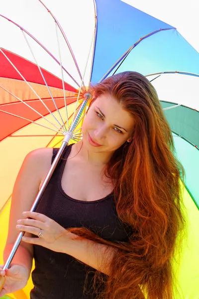 Beautiful young girl with rainbow colored umbrella — Stock Photo, Image