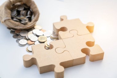 Yapbozun üç parçası madeni para yığını, iş ve mali ortaklık kavramına yapılan yatırım üzerinde toplanıyor.