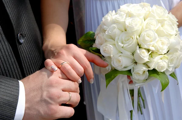 Hands with wedding rings and bouquet — Stock Photo, Image