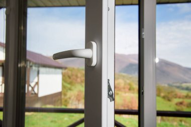 open plastic vinyl window on a mountain village landscape background