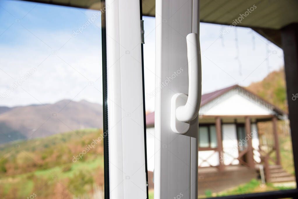 open plastic vinyl window on a mountain village landscape background