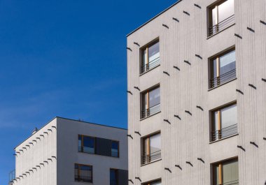 Şehrin mavi gökyüzü arka planında modern apartman binası