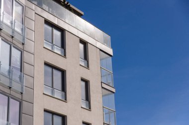 Şehrin mavi gökyüzü arka planında modern apartman binası