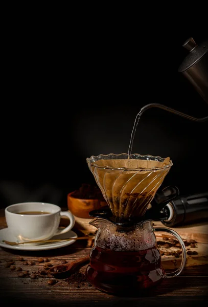 Fresh coffee. In a white coffee cup, hand-ground coffee. Black background. Drip coffee.