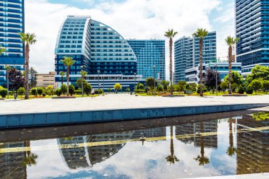 Palmiye ağaçları ve diğer ağaçlarla çevrili güzel yeni binalar.